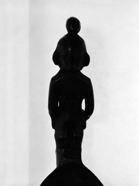 Spoon with woman carrying child on back and bundle on head