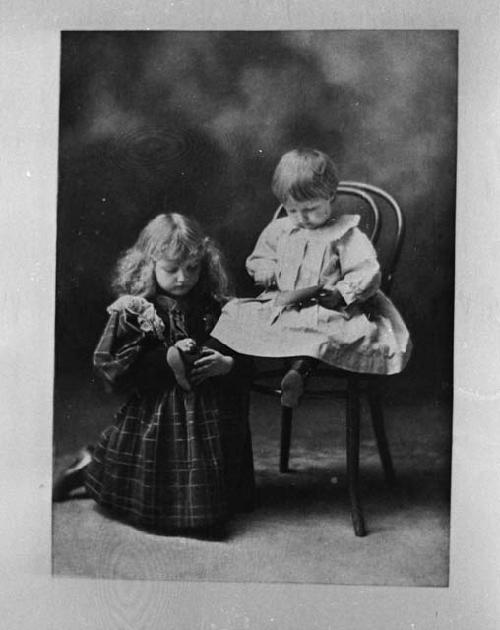 Girl next to boy sitting in chair