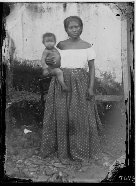 Woman standing, holding a baby