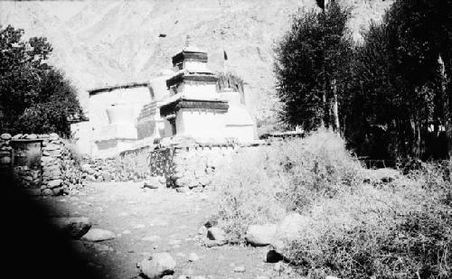 Pathway by trees, building and chortens