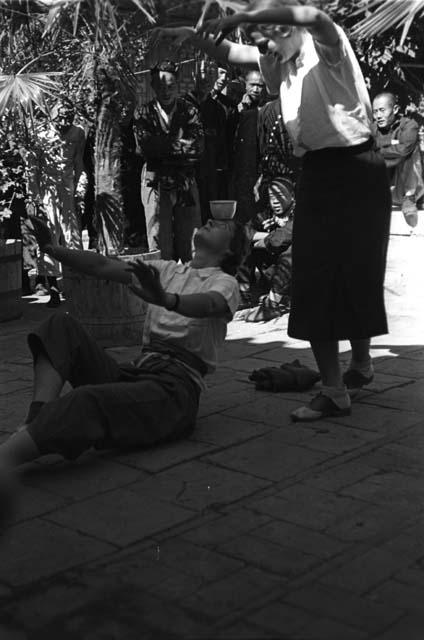 Elsie H. Perkins, raising glass of water on head