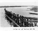 Native men standing and posing on canoe