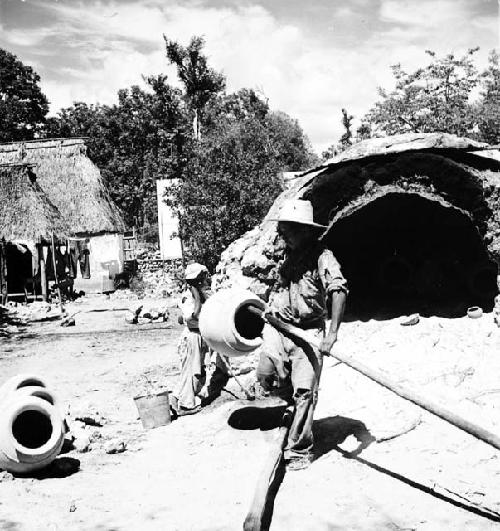 Angel Ku removing tinaja from kiln, 7 of 12