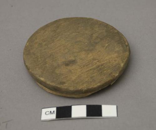 Carved wooden lid, discoidal, plain.
