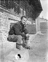 Owen Lattimore with pipe in front of building