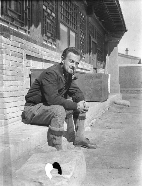 Owen Lattimore with pipe in front of building