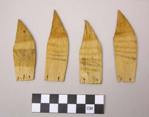 Four carved feathers or fins