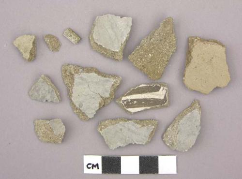 Ceramic sherds, gray or brown one side, one sherd has black designs on white