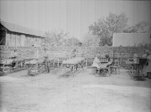 View of women and men sherd washing in the field house yard