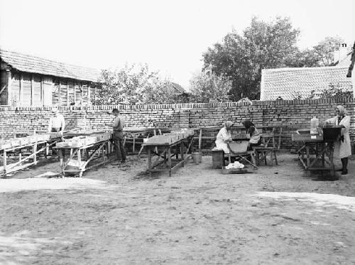 View of women and men sherd washing in the field house yard