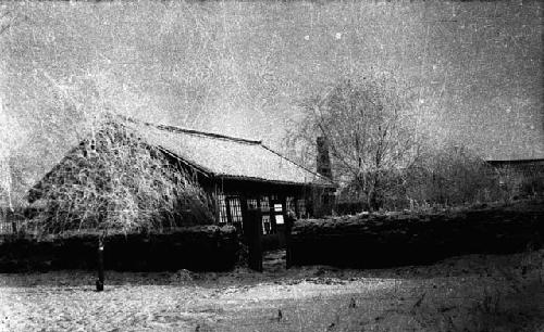 Building with trees beside it and wall around it