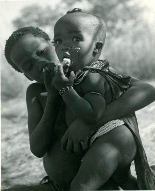 "Norna with groups": /Gaishay (son of ≠Toma) feeding mealies to his sister, !Ungka Norna (print is a cropped image)