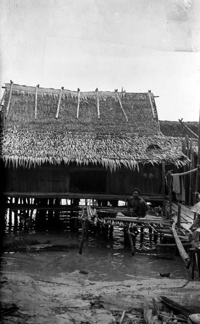 Man sitting on dock in front of house on stilts