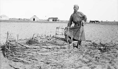 Man standing next to wicker-mouthed well