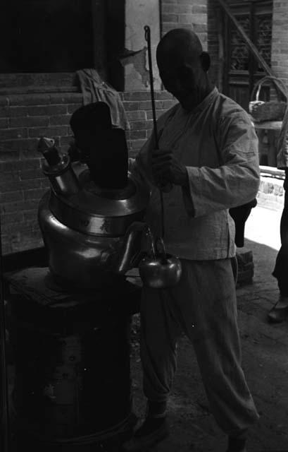 Yutaoho, Shansi, July 1935, filling small teapot from great water kettle