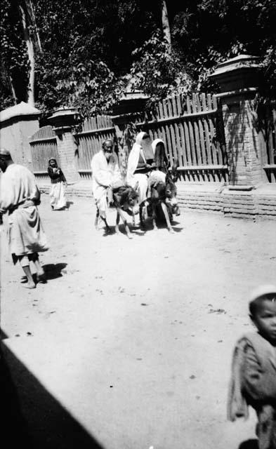 Old Turki and two of his women-folk ride past the Russian Consulate in Kashgar