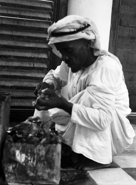 Arab opening oysters in search of pearls