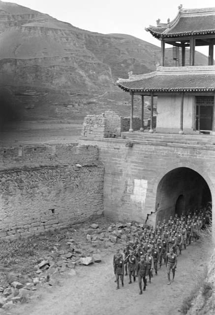 Group of soldiers marching under city gate