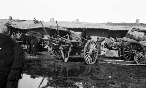 Inn yard several loaded carts, several horses