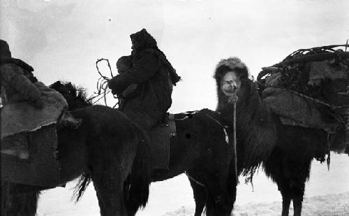 Kazak (Qazaq) woman on horse with a small child in her lap