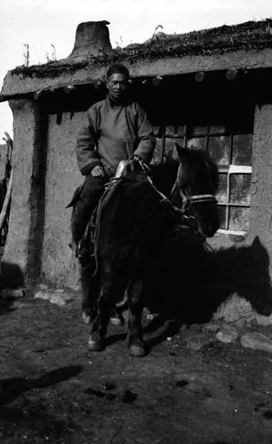 Portrait of man sitting on horse outside building