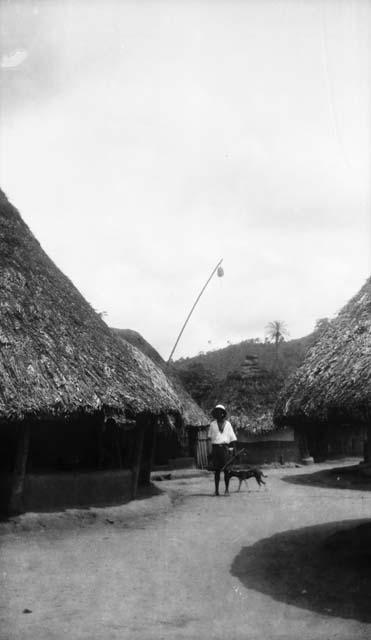 Boy with dog and umbrella, walking in village