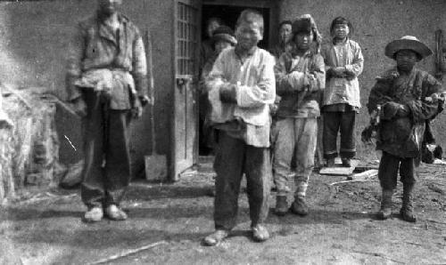 Chinese refugee settlers in Amur Valley in front of structure