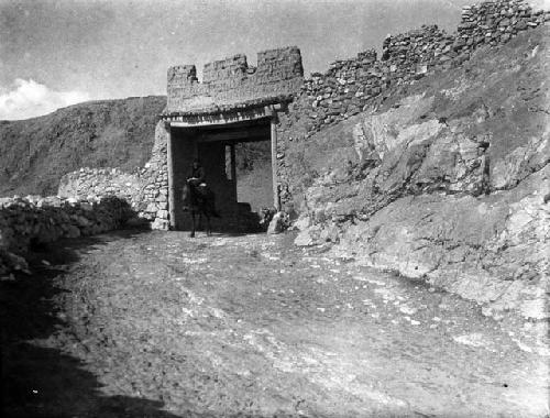 Soldier riding horse through fortified gate