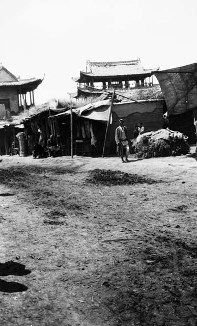 Street in Chuguchak, city gate in background, stalls in foreground