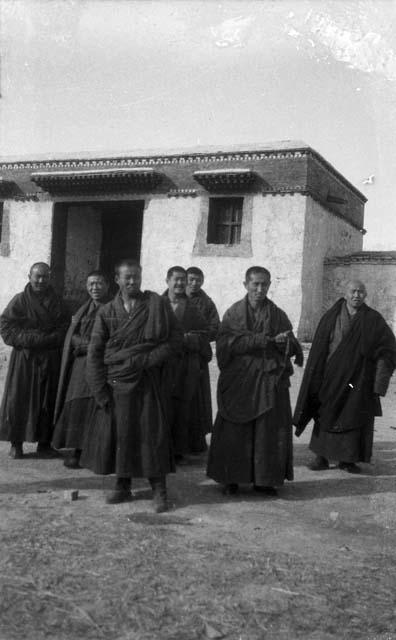 Six monks standing in front of building