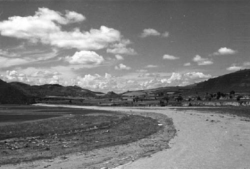 River through landscape with trees and hills in background