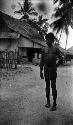 Man standing on path in front of house