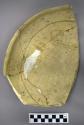 Fragments of large black on yellow pottery bowl--restored