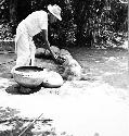 Macedonio Canul putting water on chukum-decorated hot pot