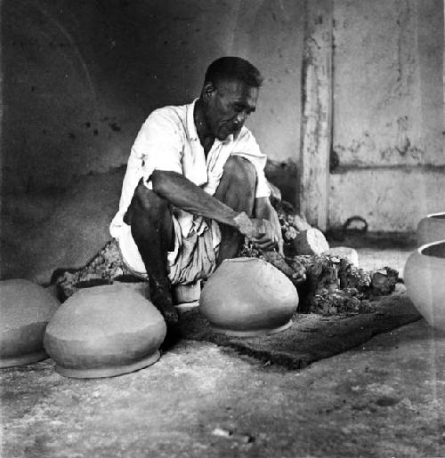 Felipe Dzul scraping bases of apastes with piece of metal