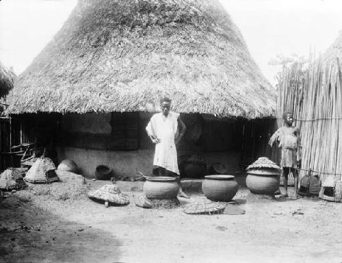 Brickyard, Man and boy in front of house with lidded ceramic pots