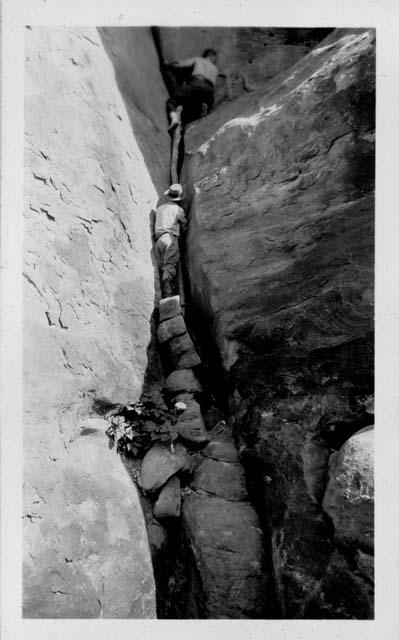 Donald Scott Jr. climbing into cave