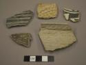 Rim sherds, some corrugated, some black on white exterior design