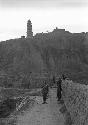 Soldier standing guard along and worker standing next to wall