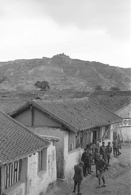 View from above of a group of soldiers standing in front of one story building