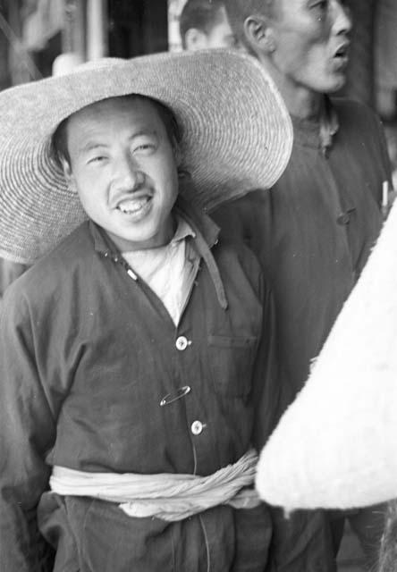 Portrait of peasant worker wearing large straw hat