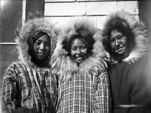 Three girls in bright calico covered fur garments
