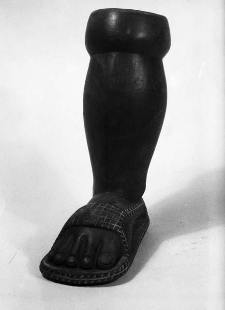 Pottery vessel in shape of human leg with sandal