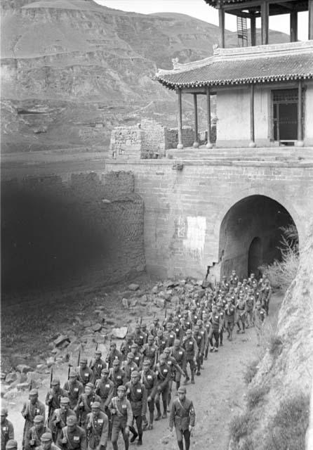 Group of soldiers marching under city gate