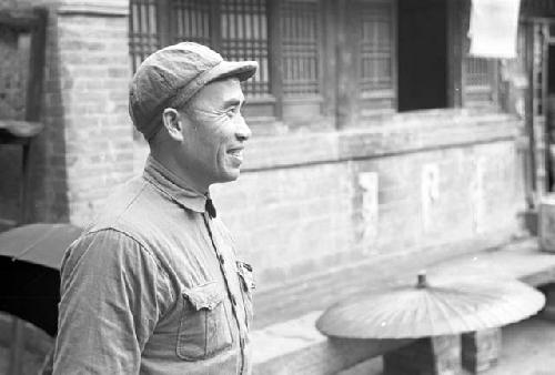 Side view portrait of General Zhu De standing in front of building