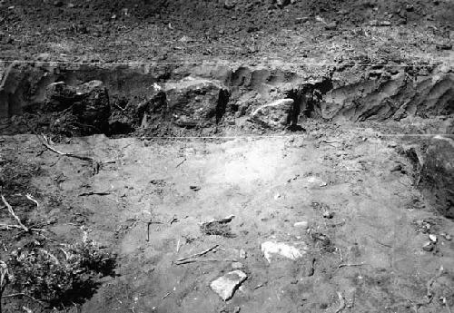 Trench through houses; showing standing slabs of central slab room