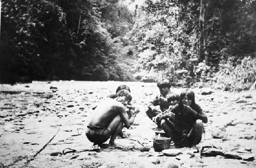 Jivaros eating near river