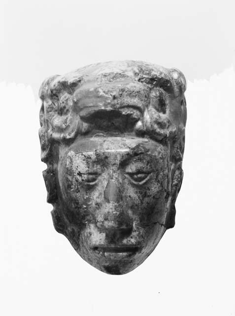 Fragment of carved Jadeite in shape of human head, front view