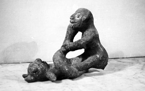 Stone sculpture; two figures and serpent intertwined