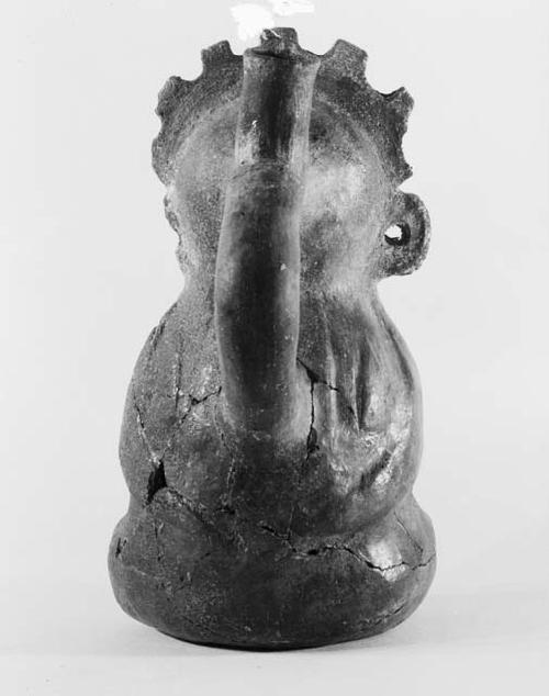 Pottery vessel - seated figure with stirrup spout